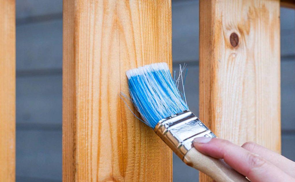 A man painting a Deck